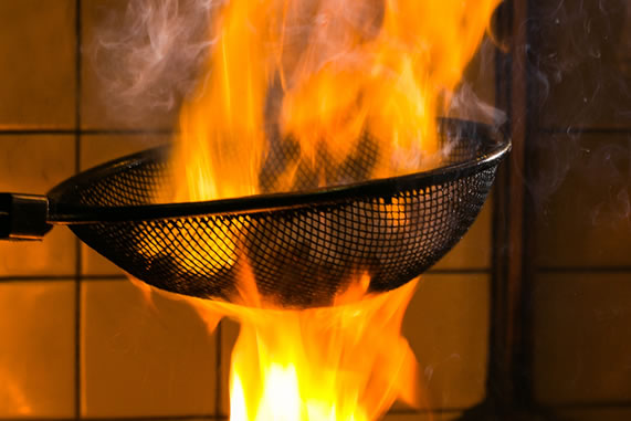 炭火から上がる炎で豪快に焼き上げる料理
